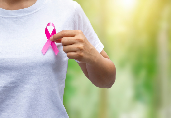 Woman holding up pink breast cancer ribbon