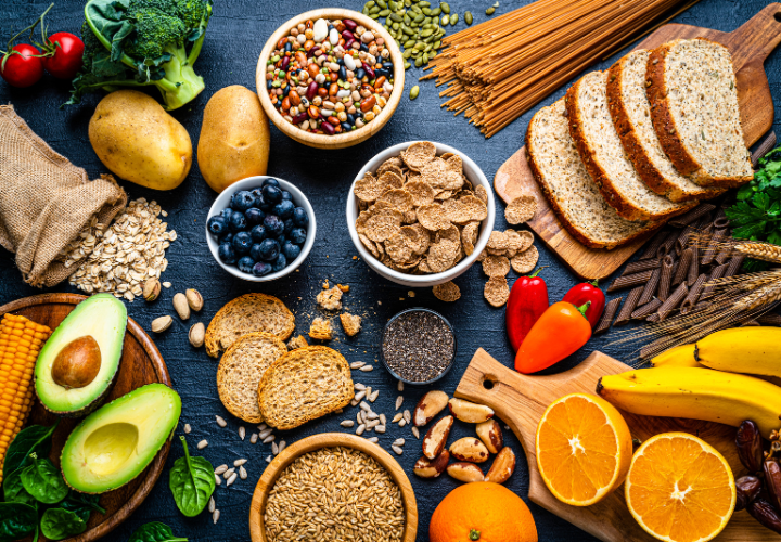 Nutrient-dense foods including salmon, avocado, sweet potato, broccoli, fruit, almonds, and beans