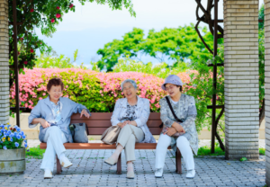 Three older Japanese women enjoying time together outdoors, highlighting social connection and healthy aging habits.